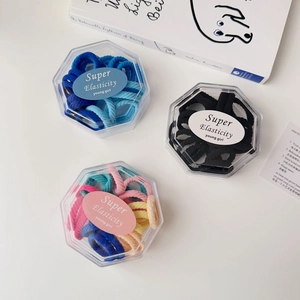 Close-up of colorful elastic hair bands in hexagonal clear boxes with ribbed textures