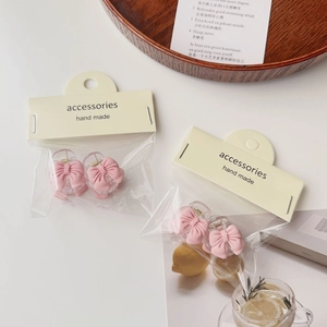 Detail of pink bow hair clips on mini handmade accessory cards in a soft lifestyle setting