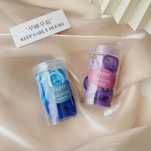 Close-up of high-elasticity hair ties in pastel blue and purple within round clear jars