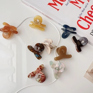 Close-up of mini acetate hair claws in various colors and patterns for daily styling