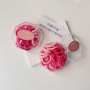 Close-up of pink high-elasticity hair ties in a transparent octagonal gift box