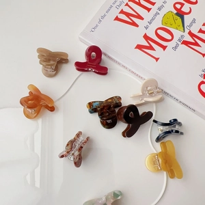Collection of colorful mini acetate hair claws in various finishes and sleek textures