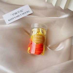 Vibrant yellow and orange elastic hair ties stored in a transparent portable jar
