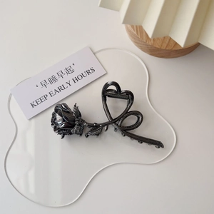 Close-up of vintage gunmetal rose hair claw clip with elegant heart line engraving
