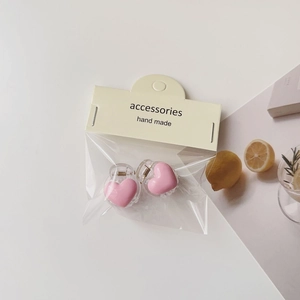 Close-up of pink heart hair clips set in transparent packaging with handmade tag