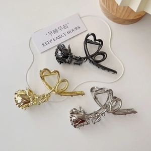 Detailed view of metal rose claw clips in black, gold, and silver finishes