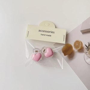 Detail of pink heart hair clips in handmade packaging with aesthetic lemon props