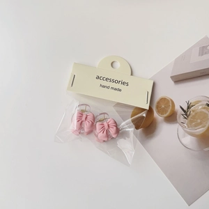 Detailed view of pink bow hair clips with camellia accents in summer lifestyle setting