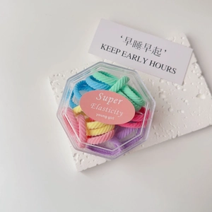 Macro view of colorful macaron hair ties set in a transparent hexagonal storage box