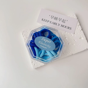 Close-up of blue high elasticity towel hair ties set in a clear hexagonal storage box