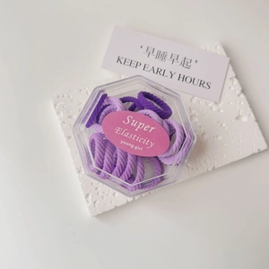 Detail of purple elastic hair ties set in a hexagonal box with high elasticity labels