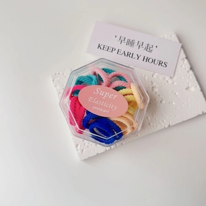 Detail of colorful elastic hair ties in a hexagonal box with soft knit texture