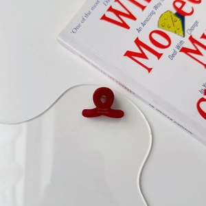 Detailed view of mini red acetate hair claw clip with golden France Handmade logo