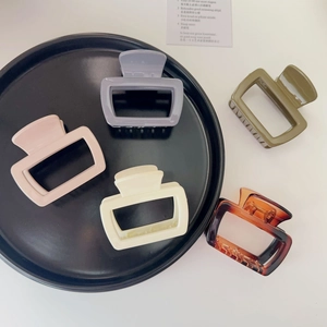Detailed macro view of five rectangular resin hair claws in Morandi tones and tortoise shell