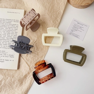 Detailed set of five vintage matte and glossy claw clips in earthy tones on paper