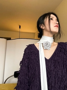 Détail d'un choker avec rose en satin faite main associé à un pull violet à franges