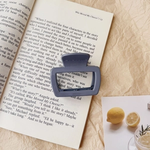 Detail of matte grey-blue rectangular hollow hair claw clip on aesthetic background