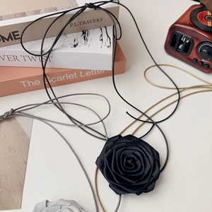 Détail macro d'un ras-de-cou fleur rose en tissu fait main avec rubans en satin noir