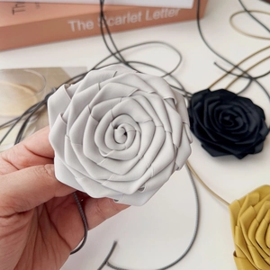 Gros plan d'un choker fleur en tissu fait main avec de grands pétales 3D et liens longs