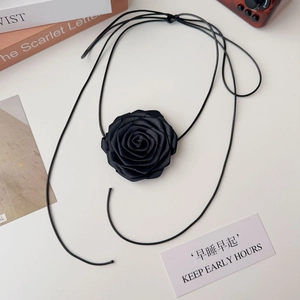 Gros plan d'un choker élégant rose en tissu noir avec longs rubans en satin doux