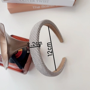 Detail view showing a 2.2cm thick black and white woven headband on a desk