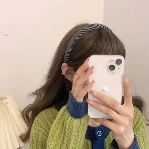 Mirror selfie showing the back view of a black and white woven padded headband on a model