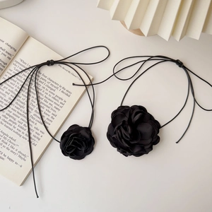 Ensemble de chokers roses en tissu noir faits main avec longs liens sur un livre