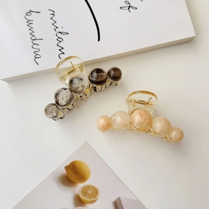Detail of amber texture marble resin hair claw clips with transparent acrylic base