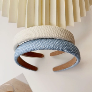 Close-up of beige and denim blue sponge headbands with woven texture and vintage style