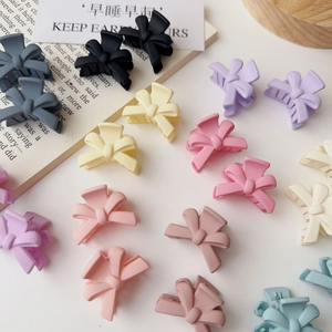 Colorful macabre bow hair clips in pastel tones arranged on a clean white surface