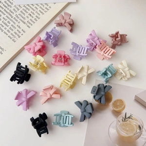 Detailed view of matte pastel mini hair claws and bow clips in various candy colors