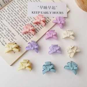 Mini macaron bow hair clips for women in pastel colors on minimalist white background