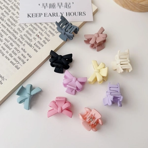 Detailed view of matte bow hair clips in various pastel colors on a clean surface