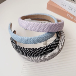 Detail showing four stylish checkered fabric headbands in pink, blue, and black textures