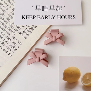 Detail shot of two pink matte butterfly hair clips on a clean decorative background