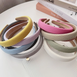 Macro shot of colorful padded headbands in yellow, pink, and blue on a glass stand