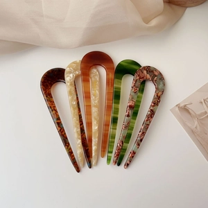 Detailed close-up showing five acetate U-shaped hair pins with marble and tortoiseshell patterns