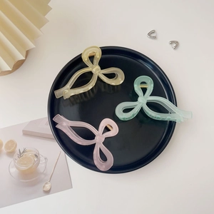 Trois grandes pinces à cheveux à nœud mat en jaune, vert et rose pastel