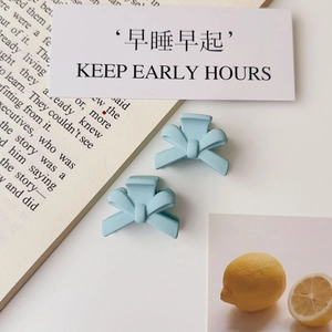 Detail shot of light blue matte bow hair clips on a minimalist lifestyle background