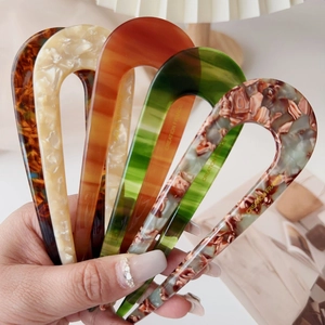 Detailed set of four U-shaped acetate hair pins in stylish marble and tortoiseshell patterns