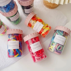 Jar of high-elasticity candy-colored hair bands for kids in various pastel shades