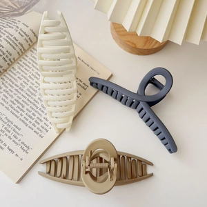 Detailed view of matte texture oversized hair claw clips in beige, blue and khaki