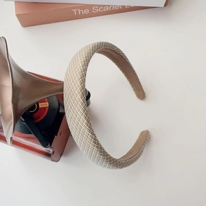 Detail of cross-woven sponge headband with beige fabric and non-slip inner lining