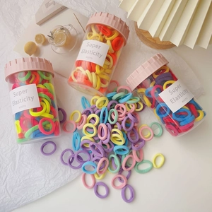 Detail of candy-colored elastic hair ties in a clear bottle for cute girls' accessories