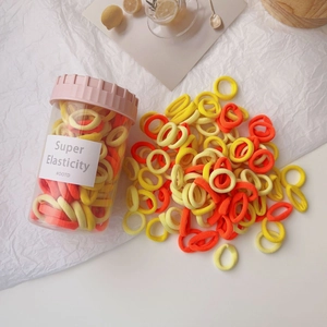 Colorful elastic hair ties for girls stored in a transparent jar with striped lid