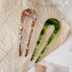 Detailed macro view of U-shaped acetate hair pins with marble and striped patterns