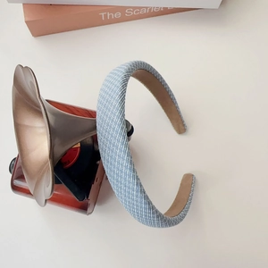 Close-up of light blue checkered sponge headband with soft woven texture and suede lining