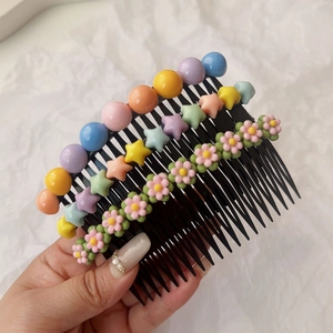 Détail d'un lot de trois peignes à cheveux avec étoiles colorées, perles et marguerites