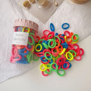 Macro shot of colorful high elasticity hair ties in a clear cylinder storage bottle