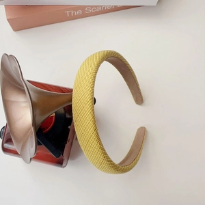 Detail of yellow woven texture headband with thick sponge padding on a white desk